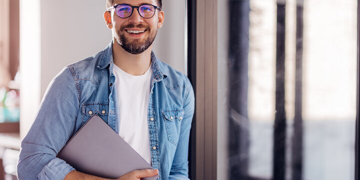 junger männlicher Student mit Laptop | © iStock/Kerkez